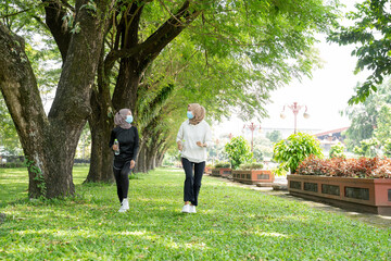 Fototapeta premium two muslim woman friend jogging together and wear a mask for virus covid protection
