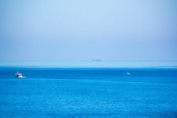 Several ships in the blue calm sea.