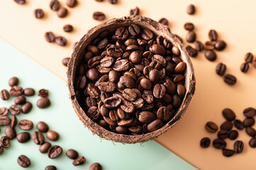 black arabica coffee beans, aromatic in a coconut dish, sprinkled beans on the table, light background, close-up, top view