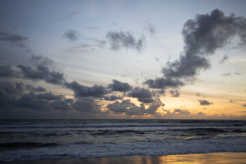 Incredibly beautiful sunset by the ocean in Bali. The bright sun sets in the water. The rays of the...