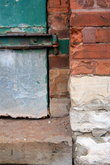 Peeling Green Window in Red and White Brick Wall with Rusty Hinges in Toronto Canada 