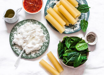 Ingredients for making cannelloni with spinach and ricotta baked with tomato sauce and mozzarella...