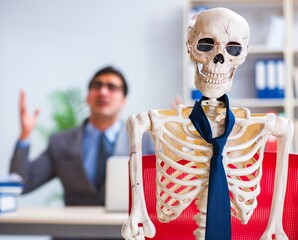 Businessman working with skeleton in office