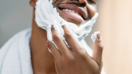 Male facial care. Skin treatment. Grooming routine. Happy confident African man applying white...