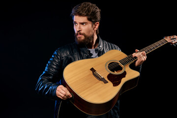 Obraz premium Cheerful man rock musician guitar playing music black background