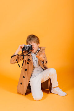 Child boy red head photographer with retro photocamera in studio