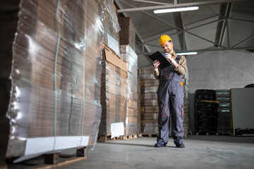 Warehouse worker checking inventory in storehouse storage department.