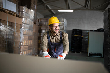 Portrait of caucasian smiling warehouse worker working on manual forklift in storage room.