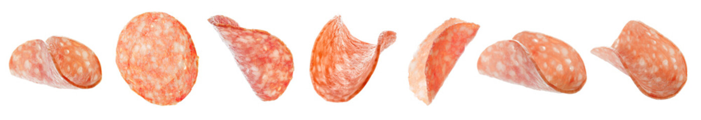 Flying slices of tasty salami on white background