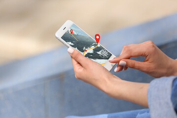 Woman using mobile phone for navigation in snowy mountains