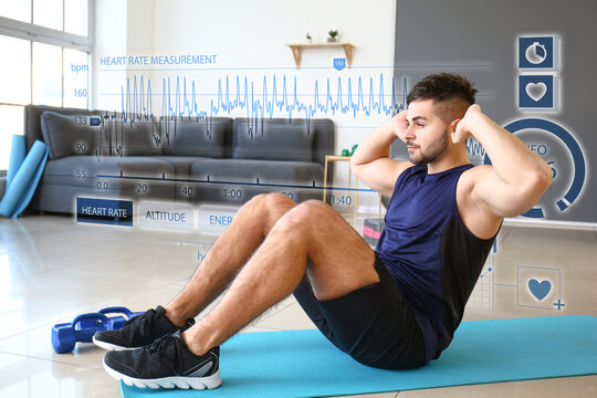 Virtual screen of heart rate monitor and sporty young man training at home