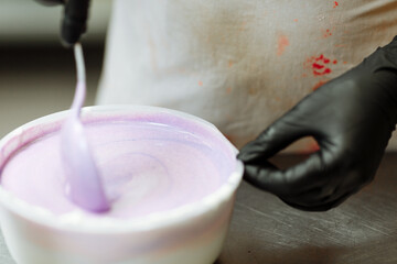 pastry chef adds purple dye and flavor to the cream for making cakes and pastries. Unhealthy food and high-calorie unnatural food. Use of harmful additives and dyes.