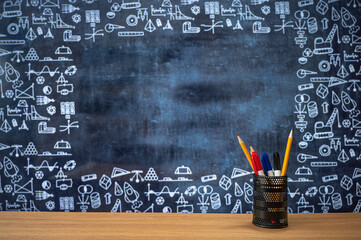 Blackboard with hand-drawn math-related icons. Pencil case on the desk. Education concept.