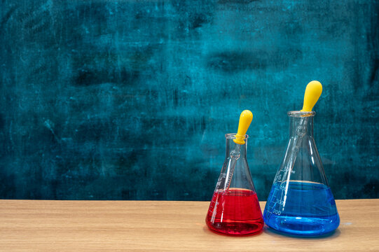 Scientific experiment tools on the desk. Empty blackboard. Education concept.