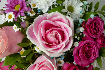 Beautiful summer background with a bouquet of bright flowers close up. Bouquet of pink roses, chrysanthemums and daisies top view