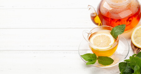 Herbal tea with mint and lemon. Tea cup and teapot