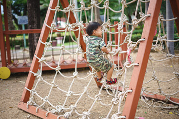 Fototapeta premium Asian boy playing and having fun at kid training playground