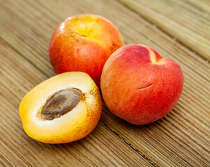 Naklejka na ściany i meble Fresh juicy apricots on wooden background, harvest season