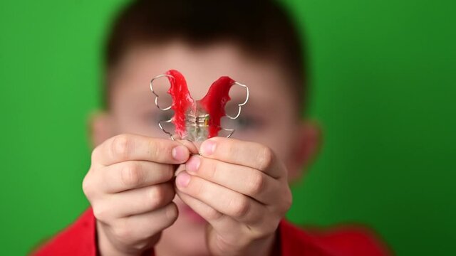 The child puts a plate on the teeth, alignment and care of teeth, alignment of the curves of permanent teeth.