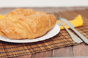 Naklejka premium croissants plates on wooden table kitchen breakfast fresh smell