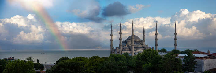 front view, sultan ahmed mosque ( Blue mosque ) in front of a cloudy day against a rainbow...