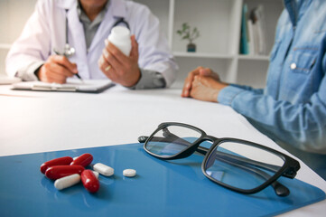 Medicine Doctor hand holding pack of different tablet blisters for patient. prescribe medicament. disease healing concept. Packaging of tablets and pills on the table.