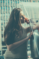 Oldstyled city. Vintage concept. Woman with payphone. Communication. Old fashion town.