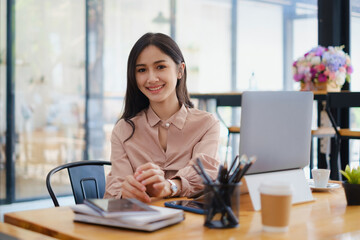 Portrait of woman sitting at her office. Attractive young confident business woman or accountant have idea for her big project.