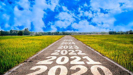 2020-2025 written on highway road in the middle of empty asphalt road and beautiful blue...