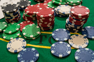 Gambling chips on green table in casino