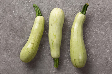 Fresh zucchini on a gray concrete background.