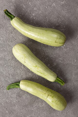 Fresh zucchini on a gray concrete background.