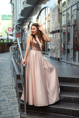 Fashion full-length portrait pretty lady in attractive ball gown dress at city street