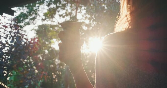 Woman drinks mate. Young caucasian woman drinks mate or chimarrao from traditional gourd