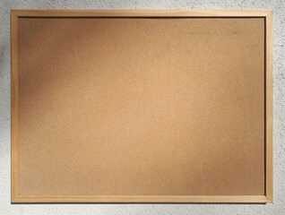 Fototapeta premium Blank cork board for notices on the wall of a house on a sunny day