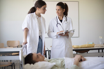 The doctor shows the student  patient's results.