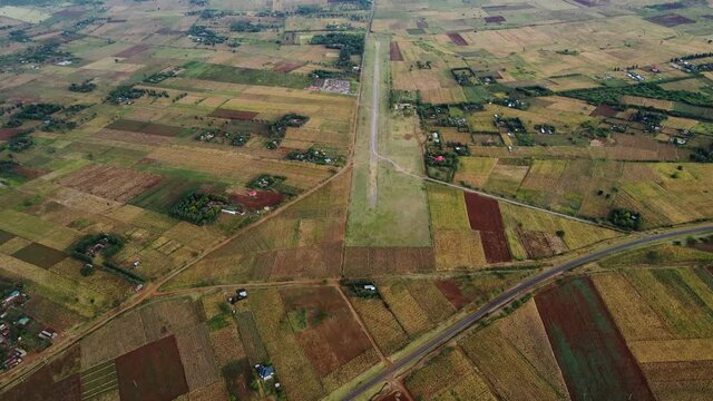 Aerial drone view high above a small aerodome, dark, overcast day, in East Africa