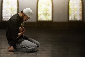 Fototapeta premium Religious asian muslim man holding holy quran