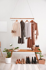 Rack with clothes in interior of modern room