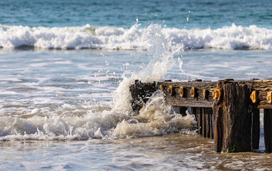 Ocean waves crushing on timber Groynes 