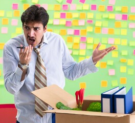 Man collecting his stuff after redundancy in the office with man