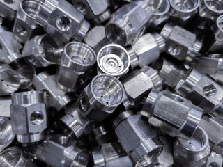 pile of abstract industrial close-up full frame background of shiny steel turned hexagonal parts