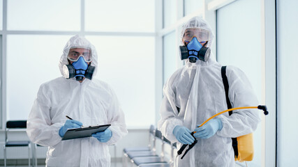 team of professional disinfectors works in a public building .