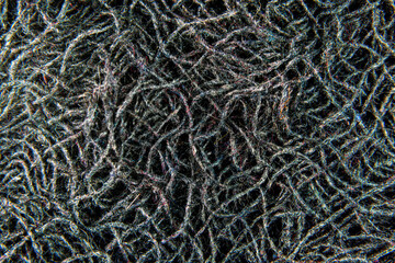 A close-up of a black net or string. A texture macro photography that shows the intricate and delicate design of the material