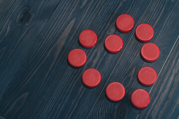 heart made of red plastic caps on a dark wooden background