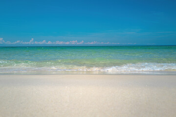 Fototapeta na wymiar Ocean blue Background. Soft blue ocean wave on sandy beach. Beautiful beach with blue sea water.