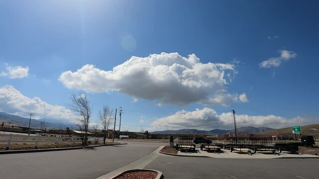 Cloudscape over a town road and parking lot in an arid climate - cumulus cloud time lapse