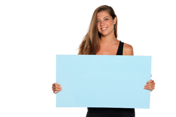 a young advertizing smiling woman holds empty board