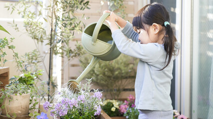 ベランダガーデニングで花に水やりする子供