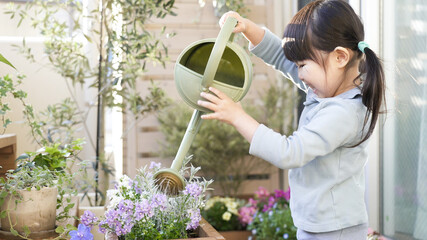 ベランダガーデニングで花に水やりする子供